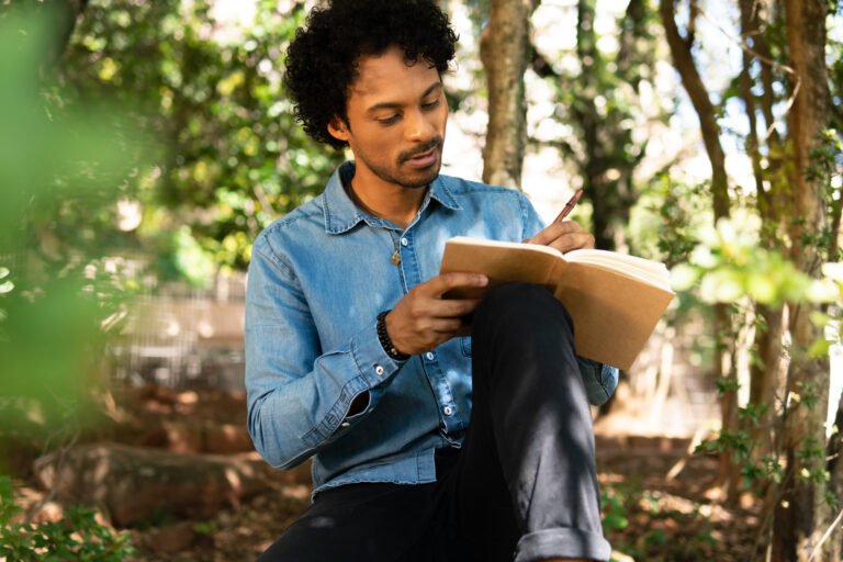 man writing in notebook ideas and enjoying nature