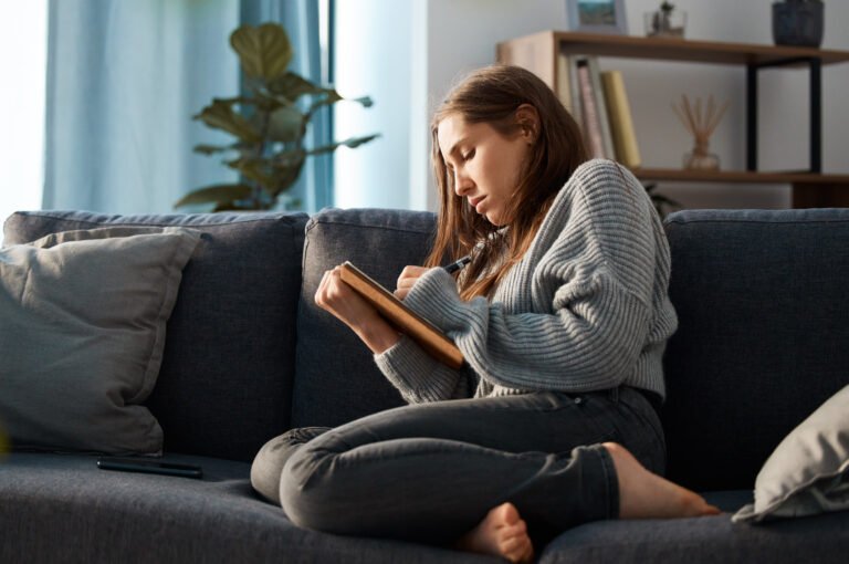 Shot of an anxious young woman writing in her journal