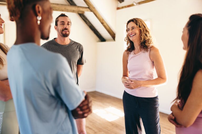 Group of people talking to a mental fitness coach in a yoga studio