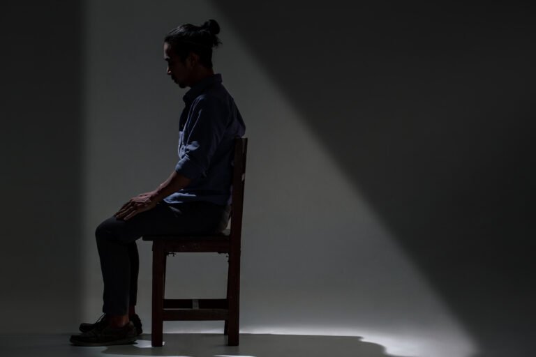 An Asian man is suffering from depression in darkness.