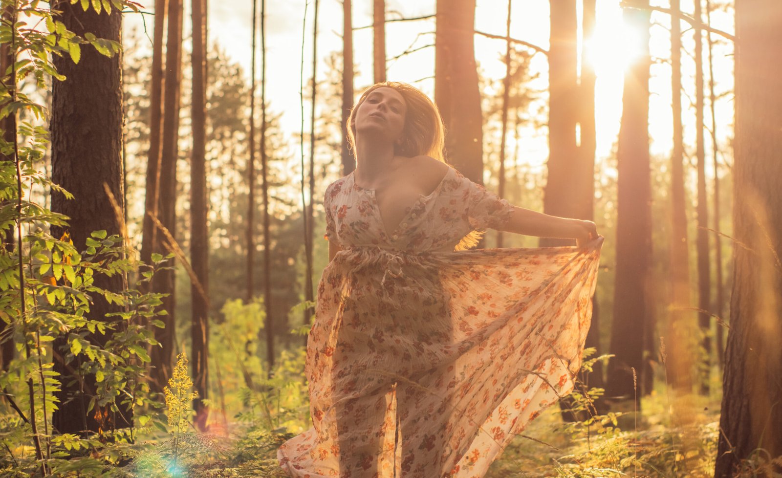 Portrait of young beautiful girl in summer dress in forest that dancing