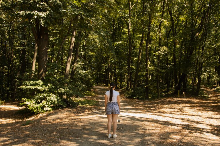 Young woman standing at a forest crossroads. symbolizing life choices and decisions. Young woman standing in Fruska Gora forest