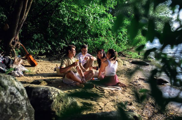 Diverse group of friends enjoying picnic by the river.