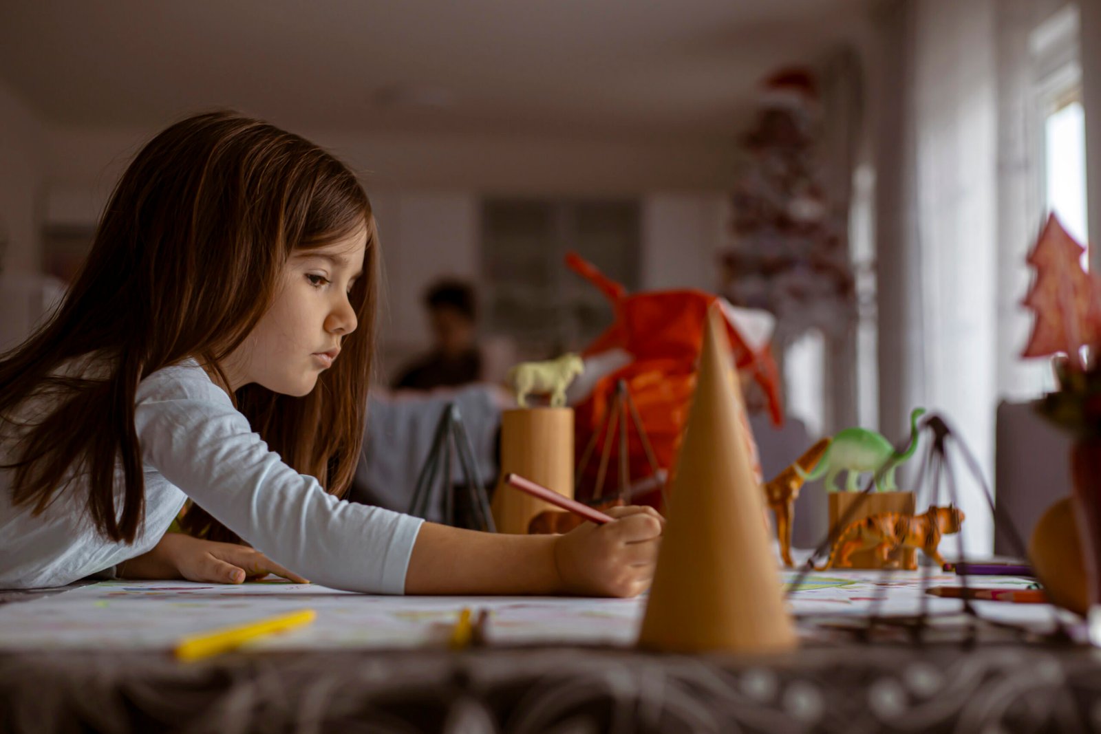 iStock photo of a girl drawing and playing with plastic toy animals and geometric figures