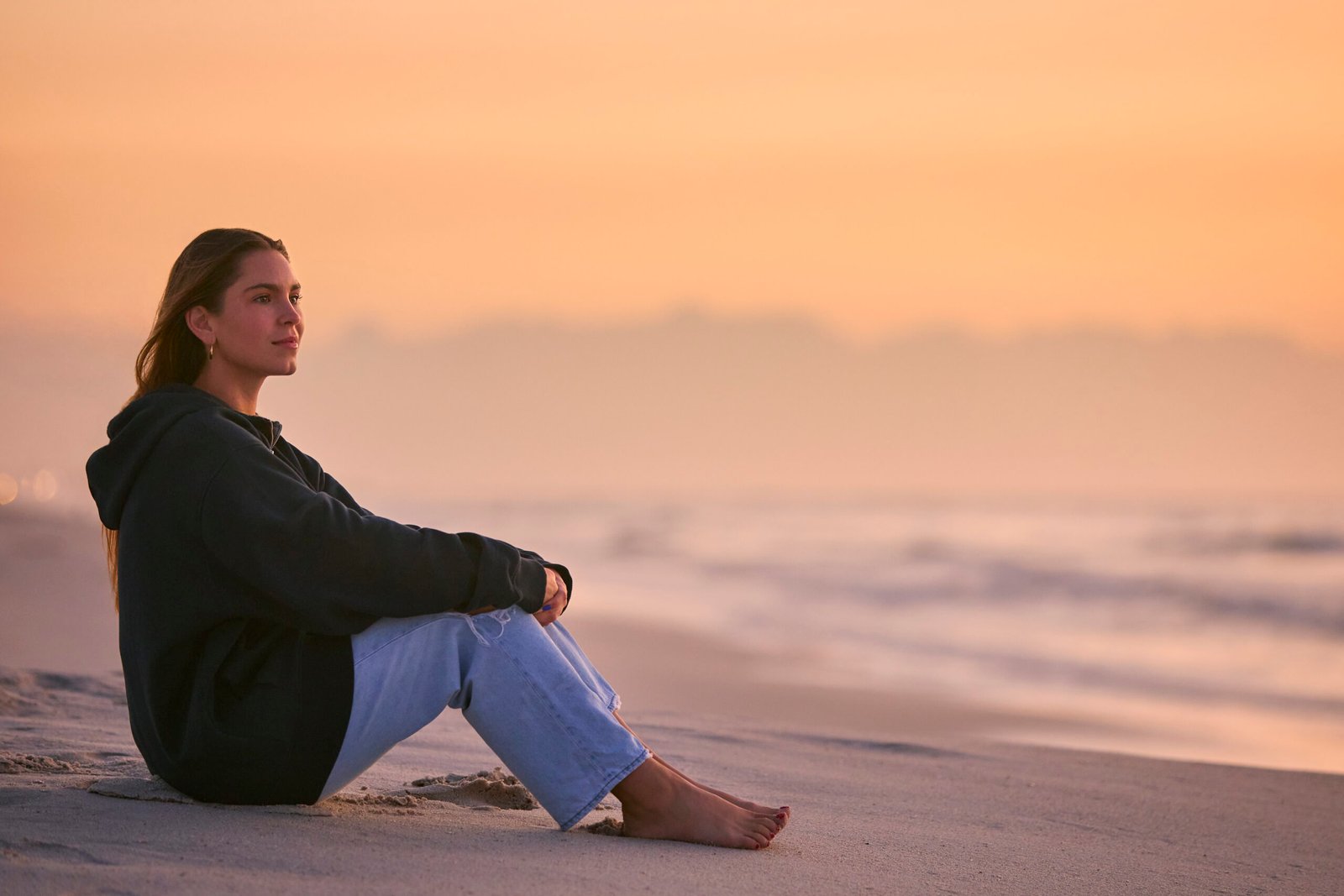 Casually Dressed Young Woman Watching Beautiful Sunrise Morning Over Beach And Sea In South Africa