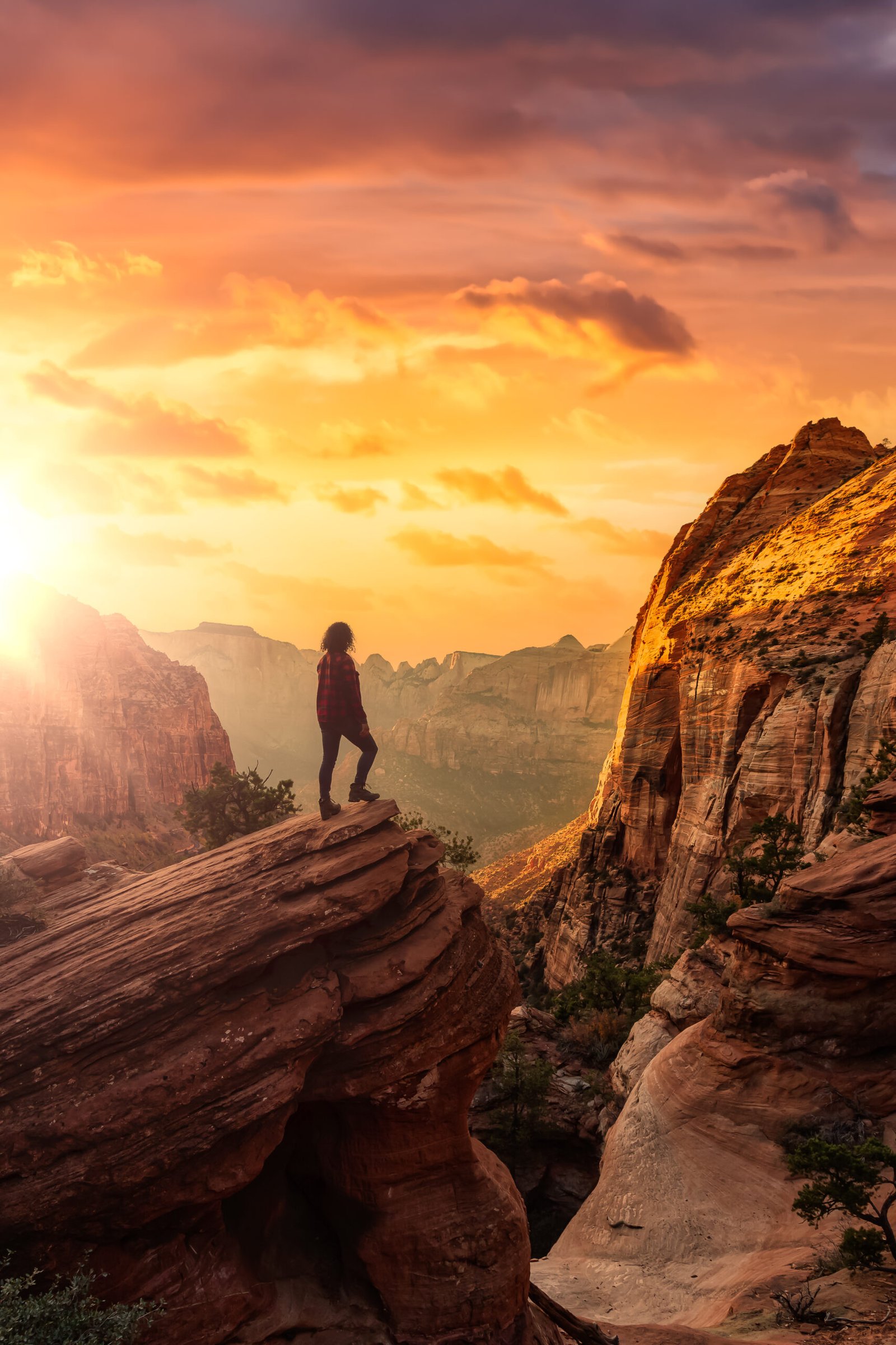 Adventurous Woman at the edge of a cliff is looking at a beautiful landscape