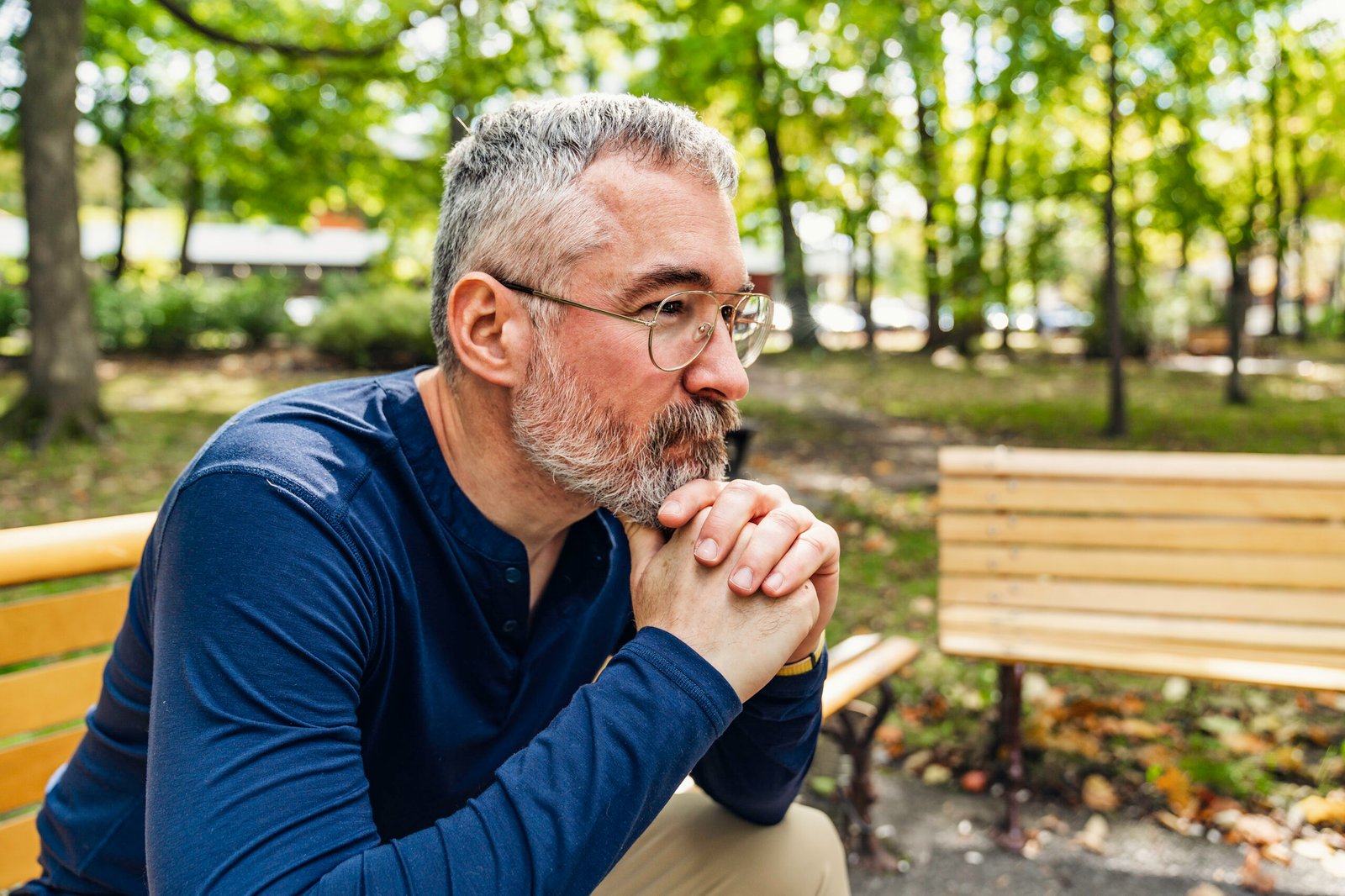Portrait of a mature man sitting on a bench in an urban park