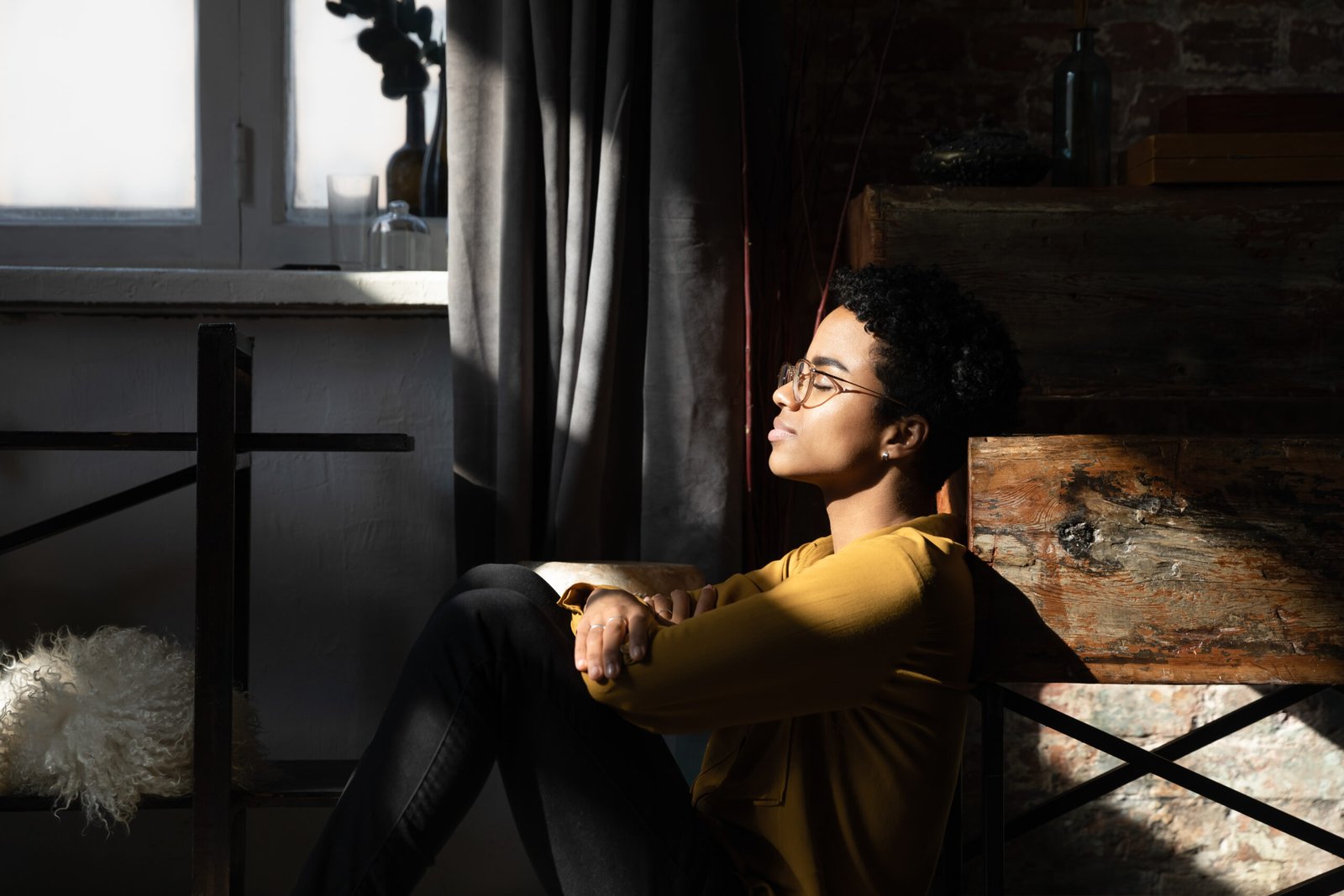 Peaceful happy young African woman, millennial girl sitting on floor