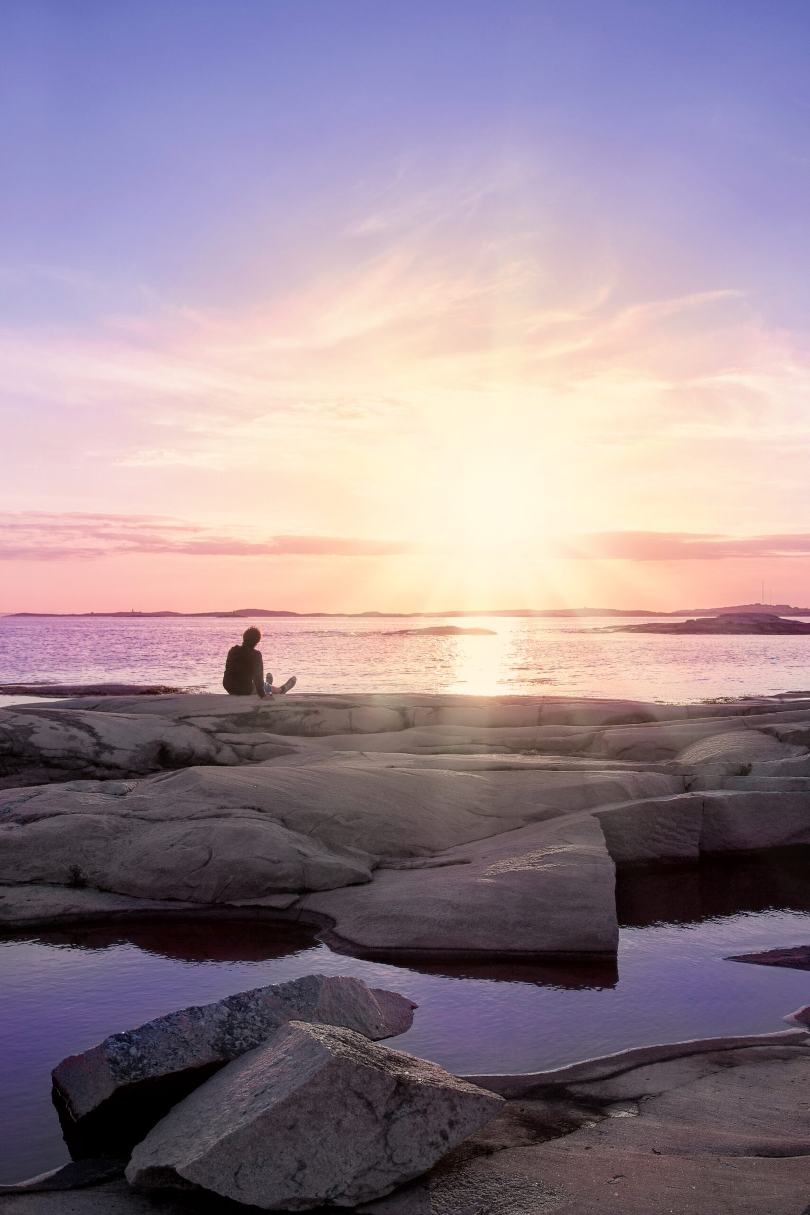 Amazing sunset with one person sitting on rock and looking at it