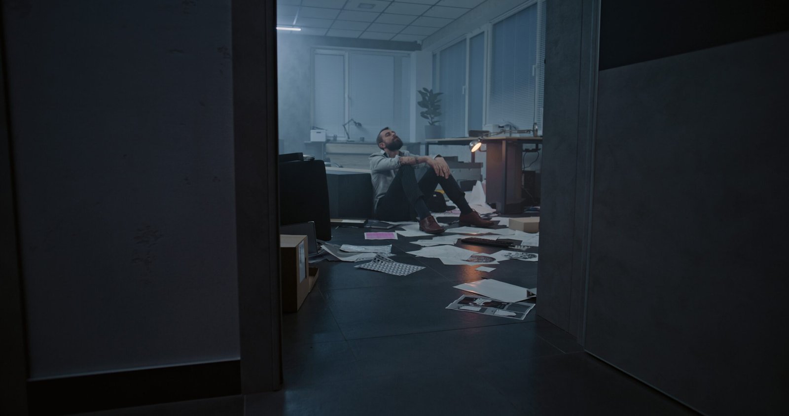 Depressed businessman in destroyed office room after financial crisis