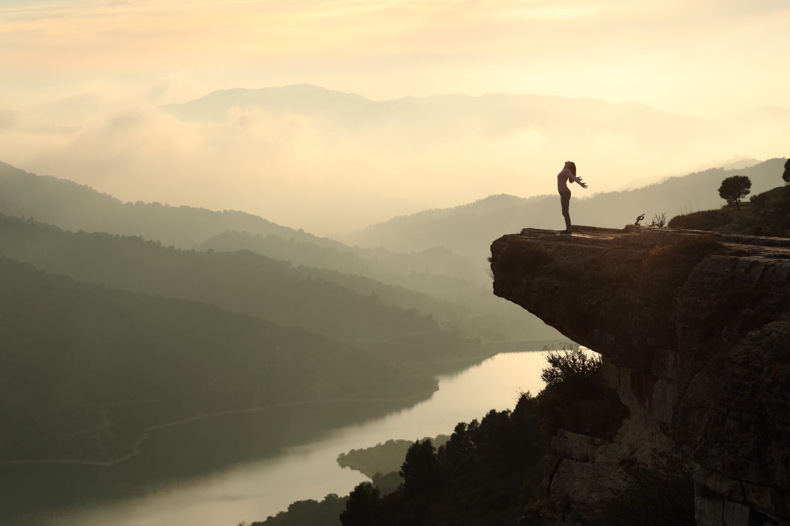 Woman in a cliff in nature breathing outstretching arms