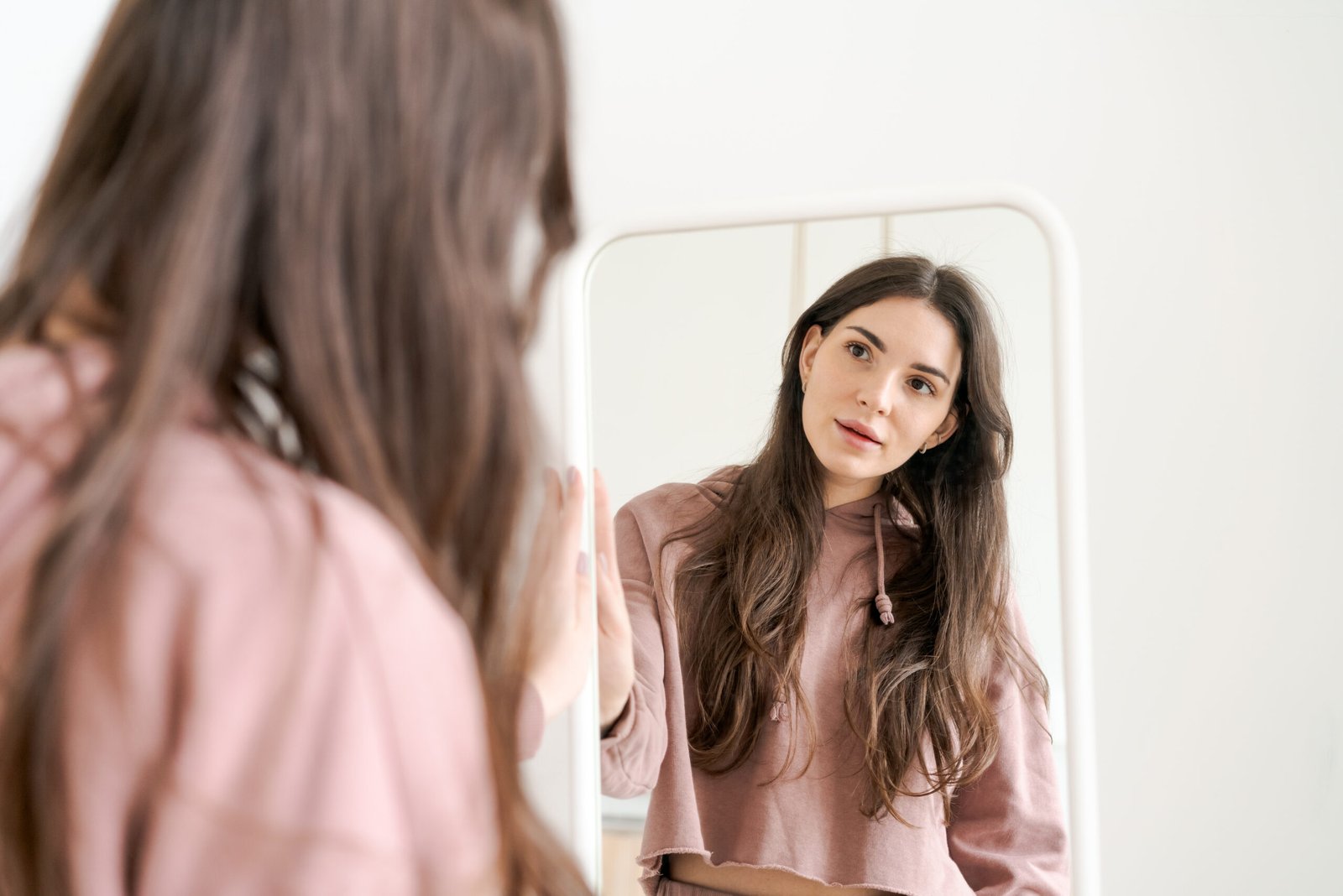 Woman is standing in front of a mirror