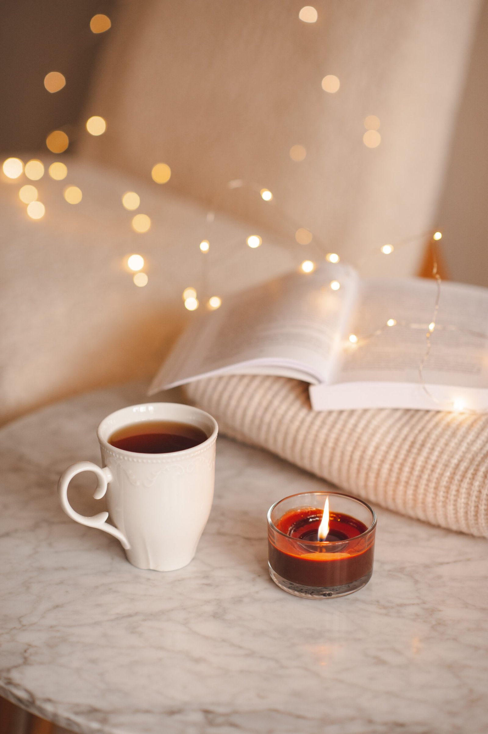 Cup of tea with candle over lights