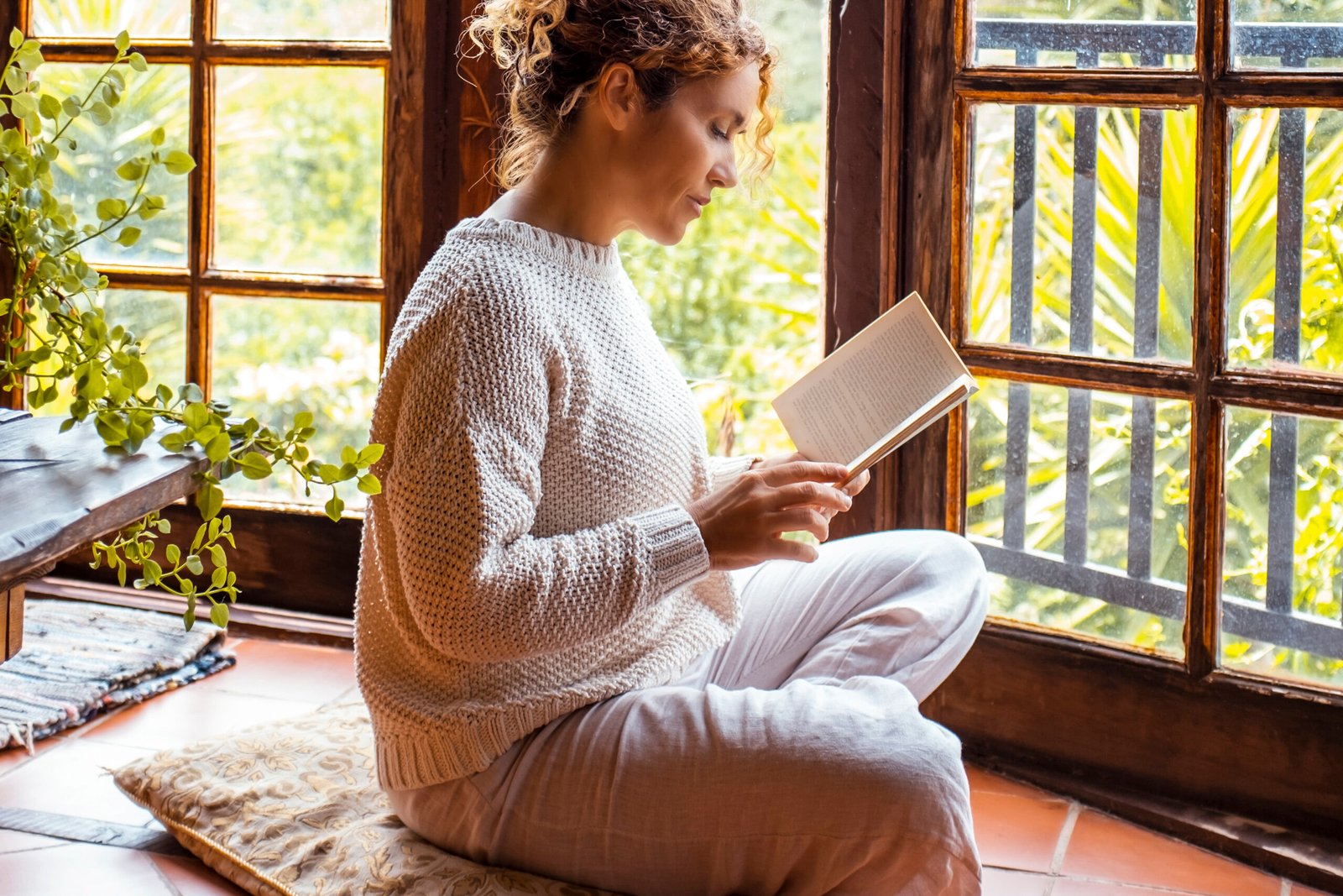 Natural lifestyle and knowledge. One young female at home sitting on the floor in mindful zen like. Healthy lifestyle and education people life concept. Enjoying house interior and relax day alone
