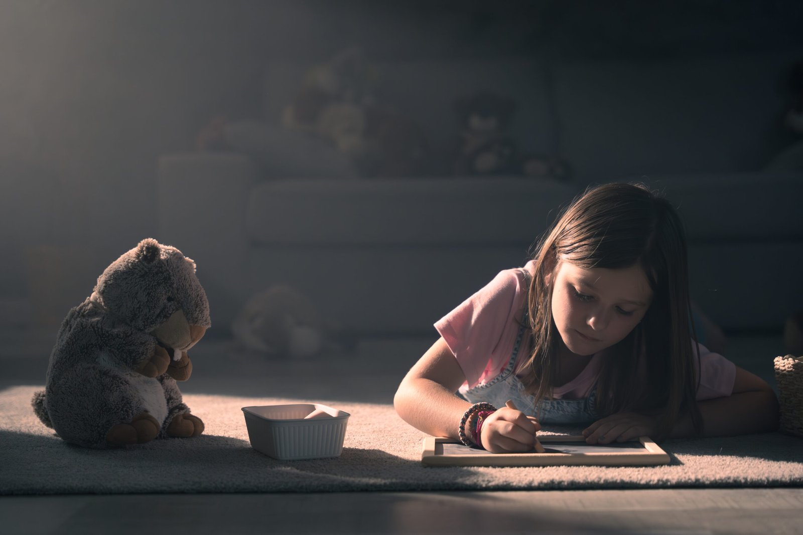 Little girl drawing lying on the floor