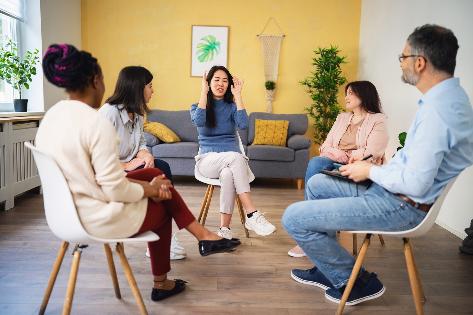 During multiracial group therapy, woman Japanese ethnicity, sharing her thoughts and emotions