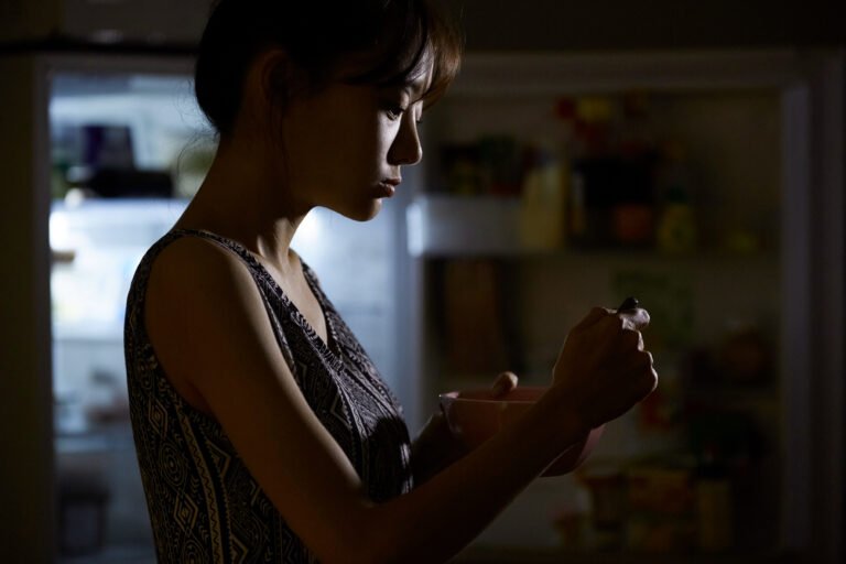 Young Asian woman eating late at night