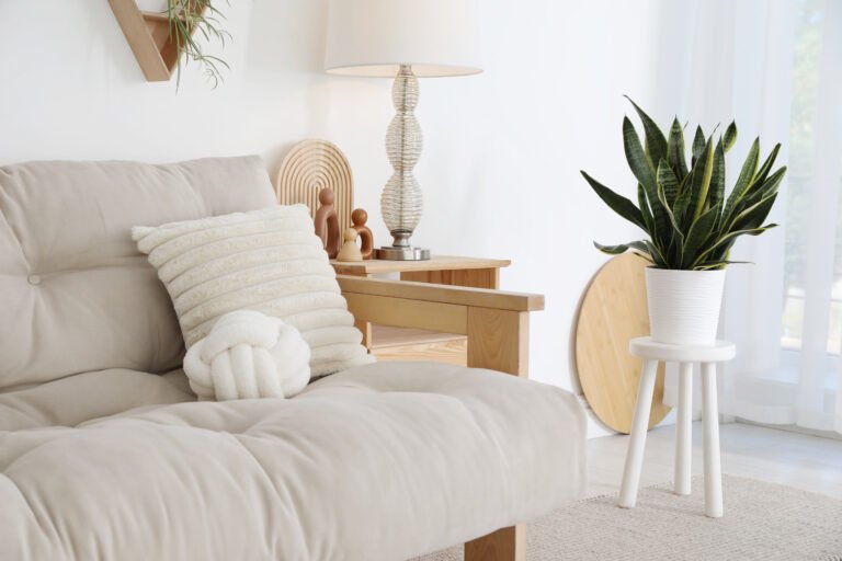 Stool, sofa, lamp and houseplant at home. Interior design