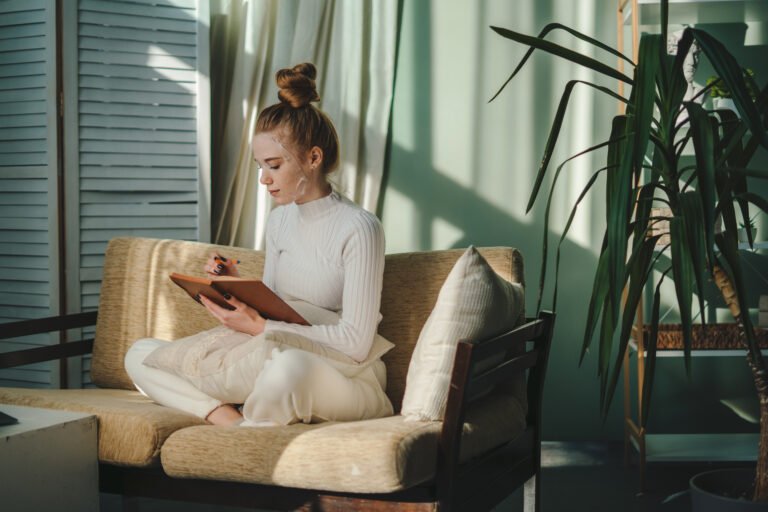 Young attractive woman writing with pencil in her journal in morning time on weekend. Leisure and recreation concept. For lifestyle design. Happy lifestyle. Relax day.