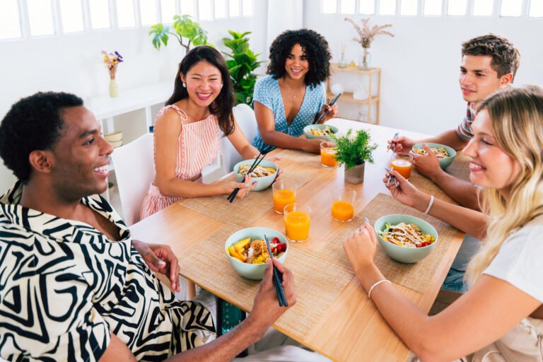 Multiethnic group of young friends meeting at home and eating poke bowls