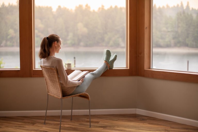 Woman reading book and relaxing at home.