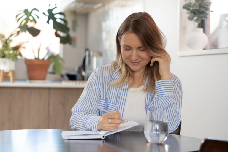 Woman writing in notebook at home with relaxed atmosphere