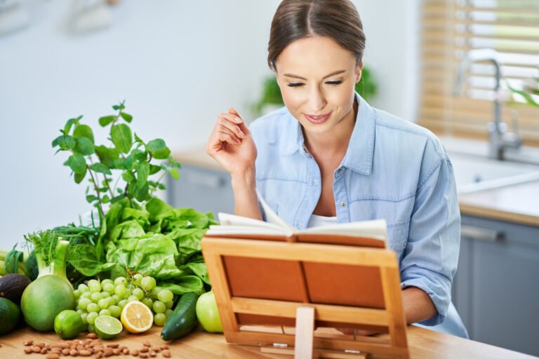 Healthy adult woman with green food in the kitchen