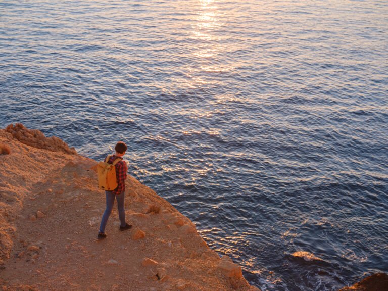 Young woman hiking on rocky beach in Spain, Benidorm