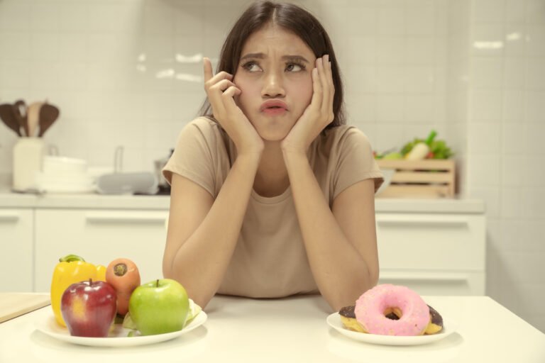 Young beautiful woman are unhappy for try to stop eat high calories and fat food