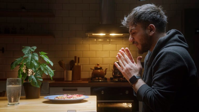 Man Eating Pizza Alone at Home in a Cozy Kitchen at Night