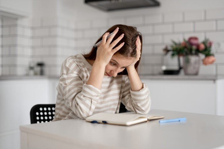 Girl Holding Head Over Notes