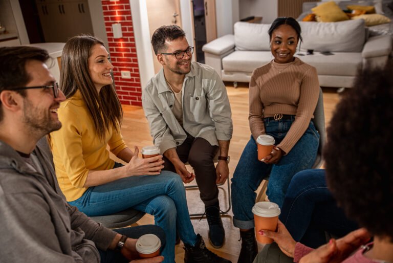 Diverse group of people sitting in circle in group therapy session.