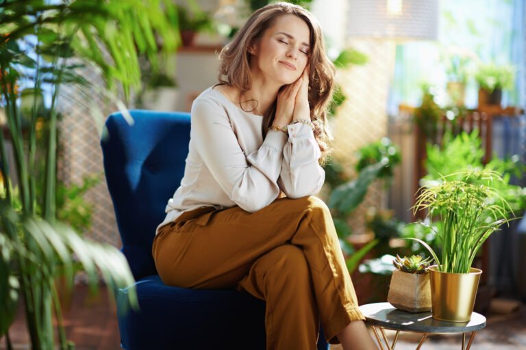 relaxed trendy woman with long wavy hair at home in sunny day