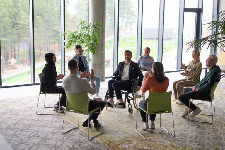 Corporate business team meeting with a manager or coach. Group of happy diverse, multiracial people sitting in a circle