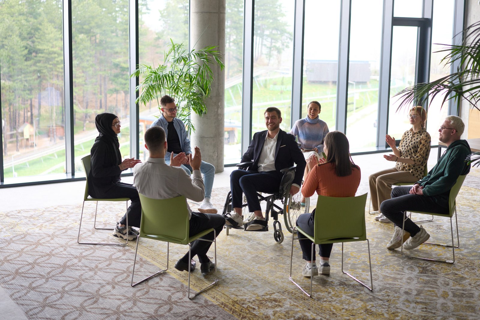 Corporate business team meeting with a manager or coach. Group of happy diverse, multiracial people sitting in a circle