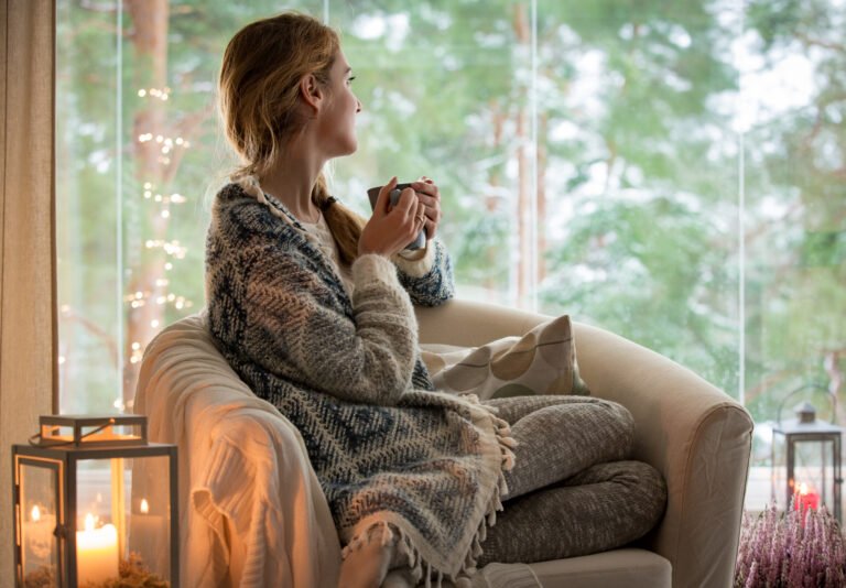 Young woman sitting home by the window