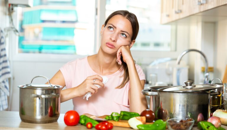 Unhappy woman trying to cook soup