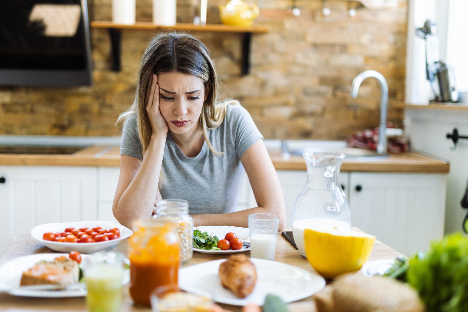 Shot of woman with no appetite in front of the meal