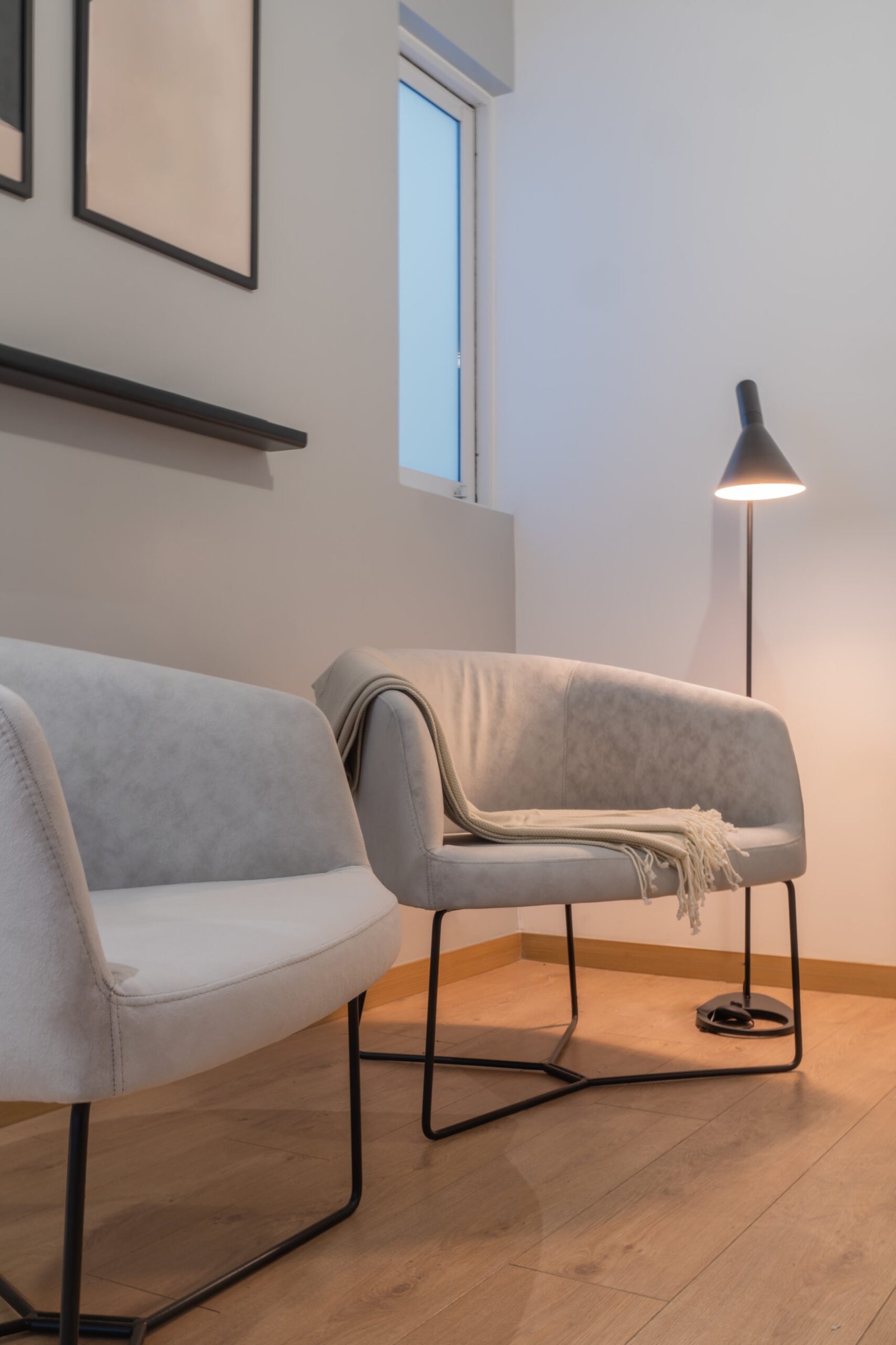Simple remodeled living room with two comfortable chairs and lamp