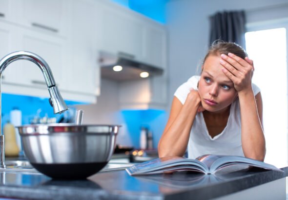 Pretty, young woman  thinking about what to cook for her family